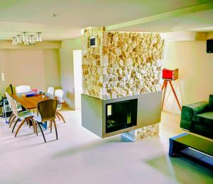 a living room with a fireplace with a table and chairs at Green Galini Villa Pelion in Káto Lekhónia