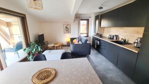 a kitchen with a table and a dining room at Le Balcon des Aiguilles - vue montagne - AravisTour in Saint-Jean-de-Sixt