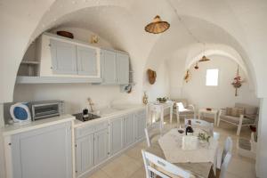 een keuken en eetkamer met witte kasten en een tafel bij Residenza "I Tre Carrubi " in Fasano +55 foto's