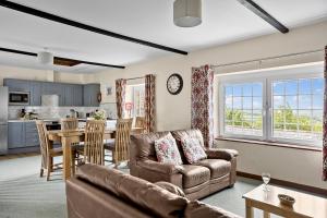 a living room with a couch and a table at Cherry Cottage in Saint Endellion