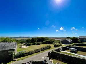 a view from the roof of a stone building with the sun at Cherry Cottage in Saint Endellion