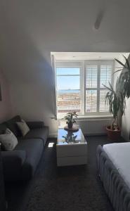 a living room with a couch and a table at Penthouse Suite, Sea View, Close to Shops, Beach and Train in St. Leonards
