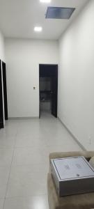 une pièce blanche avec un ordinateur portable sur un canapé dans l'établissement Buritis, à Sao Jose do Rio Preto