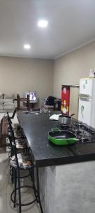 une cuisine avec une cuisinière et un comptoir avec des chaises dans l'établissement Buritis, à Sao Jose do Rio Preto