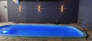 une baignoire bleue dans une salle de bains avec des lumières murales dans l'établissement Buritis, à Sao Jose do Rio Preto 8 autres photos