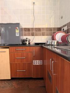 una cucina con mobili in legno e un piano di lavoro di Anand's Elegant 2BHK Apartment - AC a Mysore Altre 12 foto