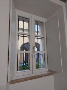 a window in a white room with two windows at Borgo delle Colonne 22 in Parma