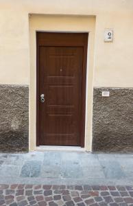 a brown door on the side of a building at Borgo delle Colonne 22 in Parma