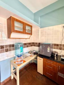 una cucina con un bancone con una boccia per i pesci su un tavolo di Anand's Elegant 2BHK Apartment - AC a Mysore