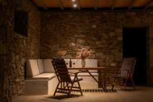 a table and chairs in a room with a stone wall at Remezzo in Ganema