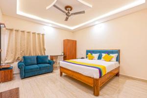 Un dormitorio con una cama y una silla azul. en Itsy Hotels Jonna Grand, en Tirupati 17 fotos más