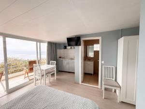 a bedroom with a bed and a table and chairs at Canto da Manu Panoramic in Calheta