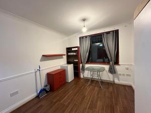 une pièce vide avec une table et une fenêtre dans l'établissement B&A House, à Romford