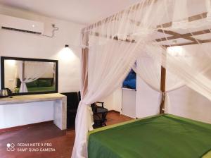a bedroom with a canopy bed and a mirror at The Glown Weligama in Weligama