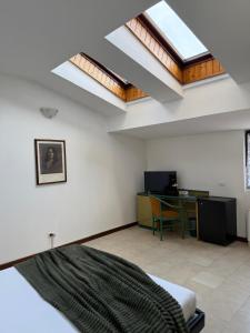 a bedroom with skylights and a desk and a bed at Residence Principe di Saronno in Saronno