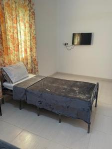 uma cama num quarto com uma televisão na parede em Home of turtles em Al Ḩadd mais 16 fotografias