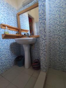 a bathroom with a sink and a mirror at AKINE TI KASSO piscine in Diembéreng