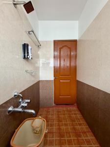 un bagno con un lavandino e una porta rossa di Anand's Elegant 2BHK Apartment - AC a Mysore