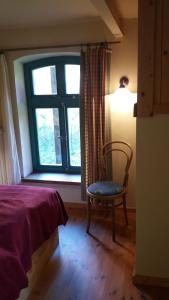a bedroom with a bed and a chair and a window at Bülitz33 in Niederdorla
