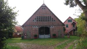 a large red brick barn with a white door at Bülitz33 in Niederdorla