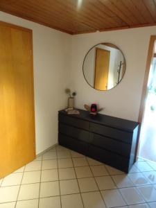a room with a dresser and a mirror on the wall at Gemütliches Apartment in Albbruck