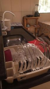 een afdruiprek met servies en keukengerei in een gootsteen bij Casa Azul Completa in Palmeiras