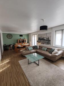 a living room with a couch and a table at Les Jacynthes in Colmar