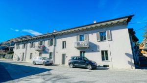 deux voitures garées devant un immeuble dans l'établissement Casa Pozzallo Giulietta - Affitti Brevi Italia, à Oulx