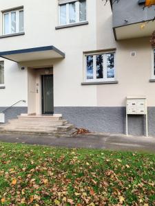 a white house with a door and a yard at Les Jacynthes in Colmar