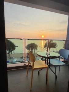 โรงแรม เซิร์ฟบีช Surf Beach Hotel في جومتين بيتش: غرفة بها طاولة وكراسي ونافذة كبيرة