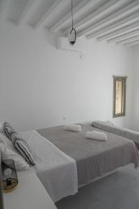 a white room with a bed with two towels on it at Remezzo in Ganema