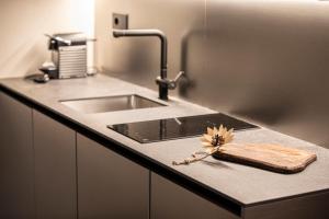 een aanrecht met een wastafel en een houten snijplank bij L'Atelier du Temps - Maison Ida in Courmayeur +19 foto's