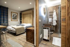 een slaapkamer met een bed en een badkamer met een douche bij L'Atelier du Temps - Maison Ida in Courmayeur