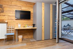 een kamer met een tafel en een televisie aan de muur bij L'Atelier du Temps - Maison Ida in Courmayeur