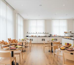 a large room with tables and chairs and a kitchen at Doksanlar Apart 