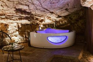 a bath tub in a stone room with a chair at Casa di Lucy Spello in Spello