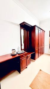 Una cocina con gabinetes de madera en una habitación. en Comodita Inn, en Ernakulam