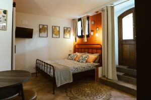 a small bedroom with a bed and a table at Casa di Lucy Spello - Cave Wellness & Panoramic View in Spello +72 photos
