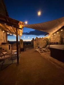 a patio with chairs and a white canopy at night at Casa di Lucy Spello in Spello