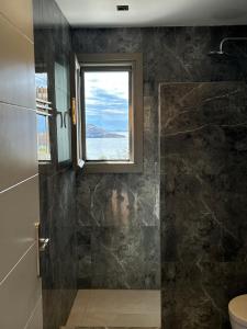 a bathroom with a shower with a window at Remezzo in Ganema