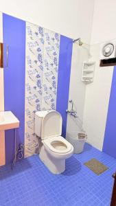 Un baño con inodoro y suelo de baldosas azules. en Comodita Inn, en Ernakulam