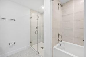 Un baño blanco con ducha y bañera. en RIVER FLY IN Merritt Island Launchpad Lookout View, en Audubon