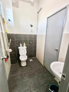 een badkamer met toilet en wastafel bij Homestay Nad 3R 3BR in Port Dickson