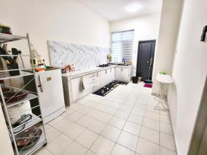 een keuken met witte apparatuur en een witte tegelvloer bij Homestay Nad 3R 3BR in Port Dickson +10 foto's
