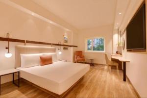 新德里Hotel De Rosewood Inn -Near Delhi Airport-Free Airport Drop的卧室里有一张白色的大床和一张书桌