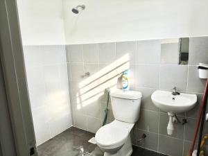 een badkamer met toilet en wastafel bij Homestay Nad 3R 3BR in Port Dickson