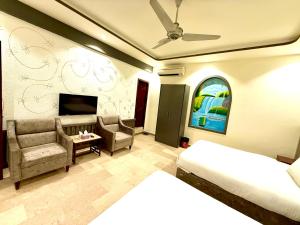 a bedroom with a bed and a couch and a tv at Blue Moon Residency Jinnah Super in Islamabad +82 photos