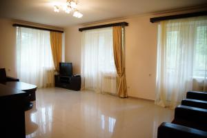 a living room with white curtains and a television at Green Hills Resort in Hankʼavan