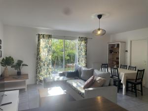 a living room with a couch and a table at Les Villas de Castel - villa "Les Muriers" in Castelmaurou