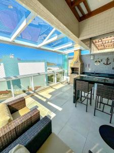 a living room with couches and a table and a fireplace at Hospedatom - Cobertura Vista Mar com Piscina Arraial do Cabo in Arraial do Cabo